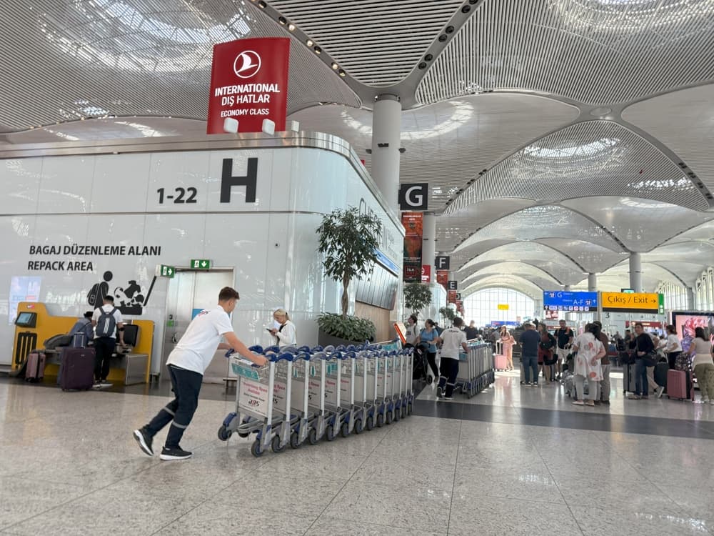 Passengers boarding at Istanbul Airport gate — departure area with aircraft view